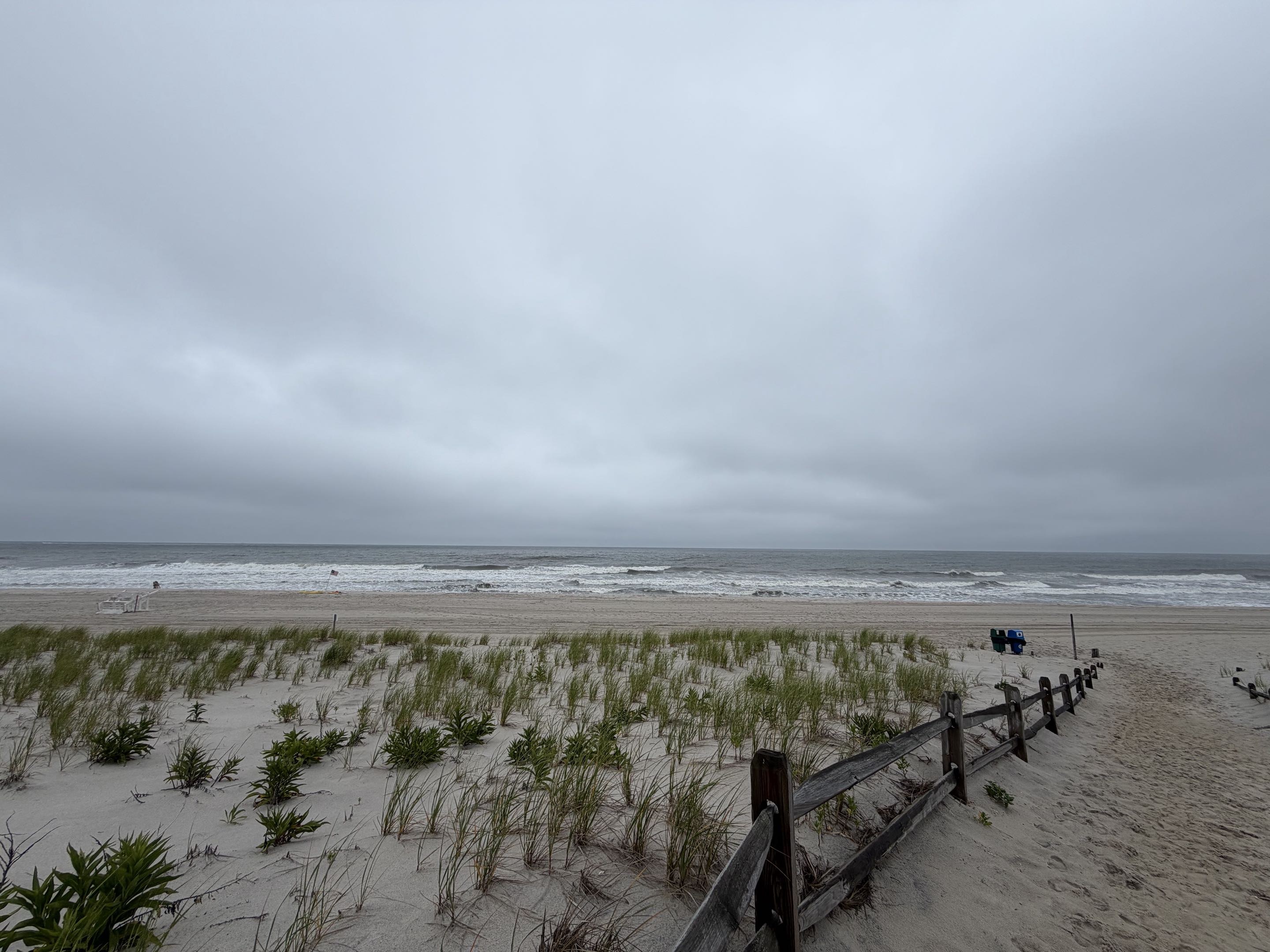 An Ocean County, NJ beach with dune grass and a split-rail fence, overcast day